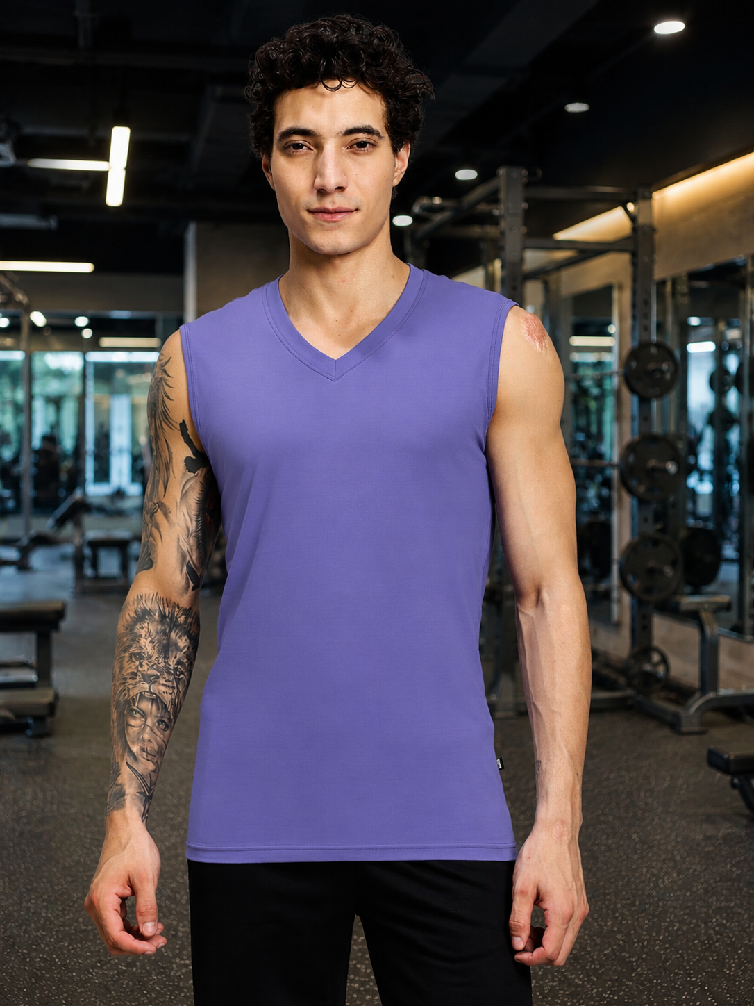 LEVELUP GAMER SLEEVELESS T-SHIRT PURPLE worn by a man in a gym setting, showcasing its vibrant color and stylish design.