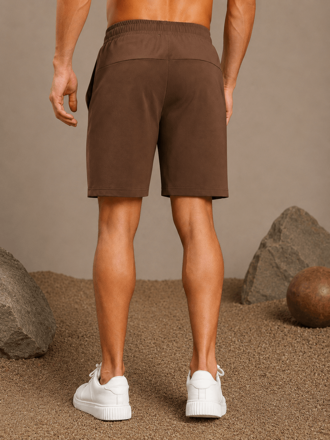 Back view of SLIM-FIT SOLID REGULAR SHORTS BROWN worn with white sneakers on neutral background.