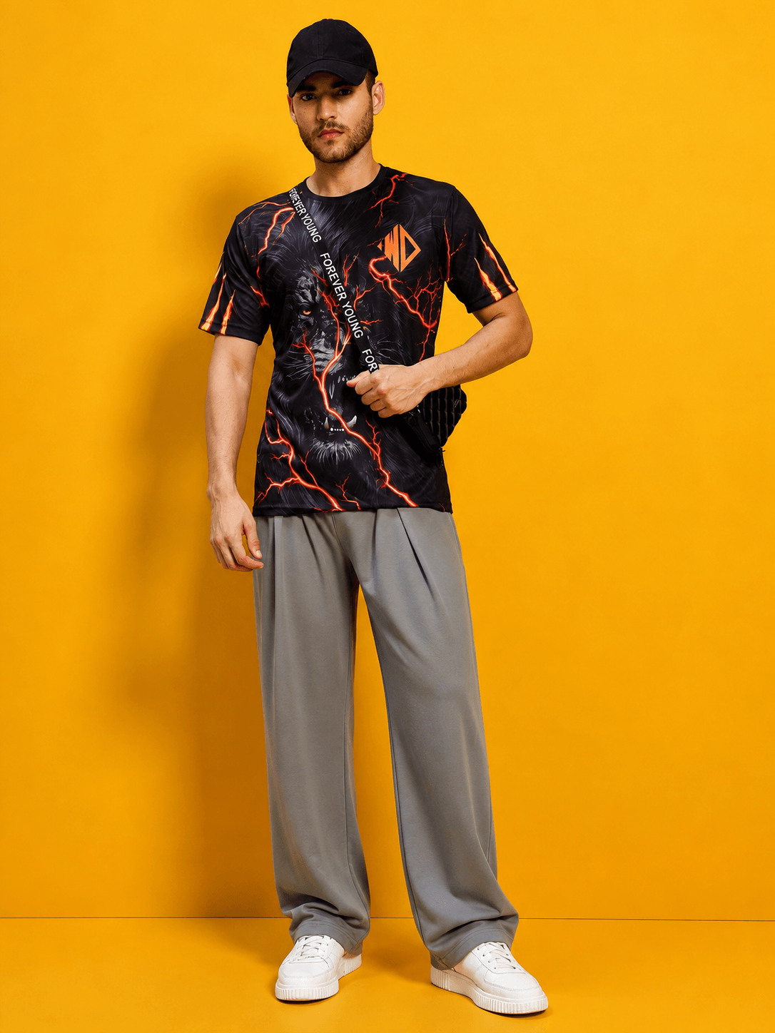 Stylish model wearing DRAPE TAILORED FIT JOGGERS GREY and graphic t-shirt against a vibrant yellow background.