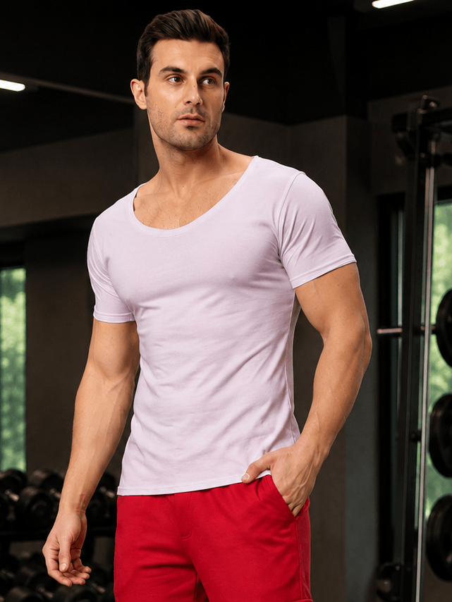 Man wearing a RICKY REGULAR FIT T-SHIRT LILAC in a gym setting with weights in the background.