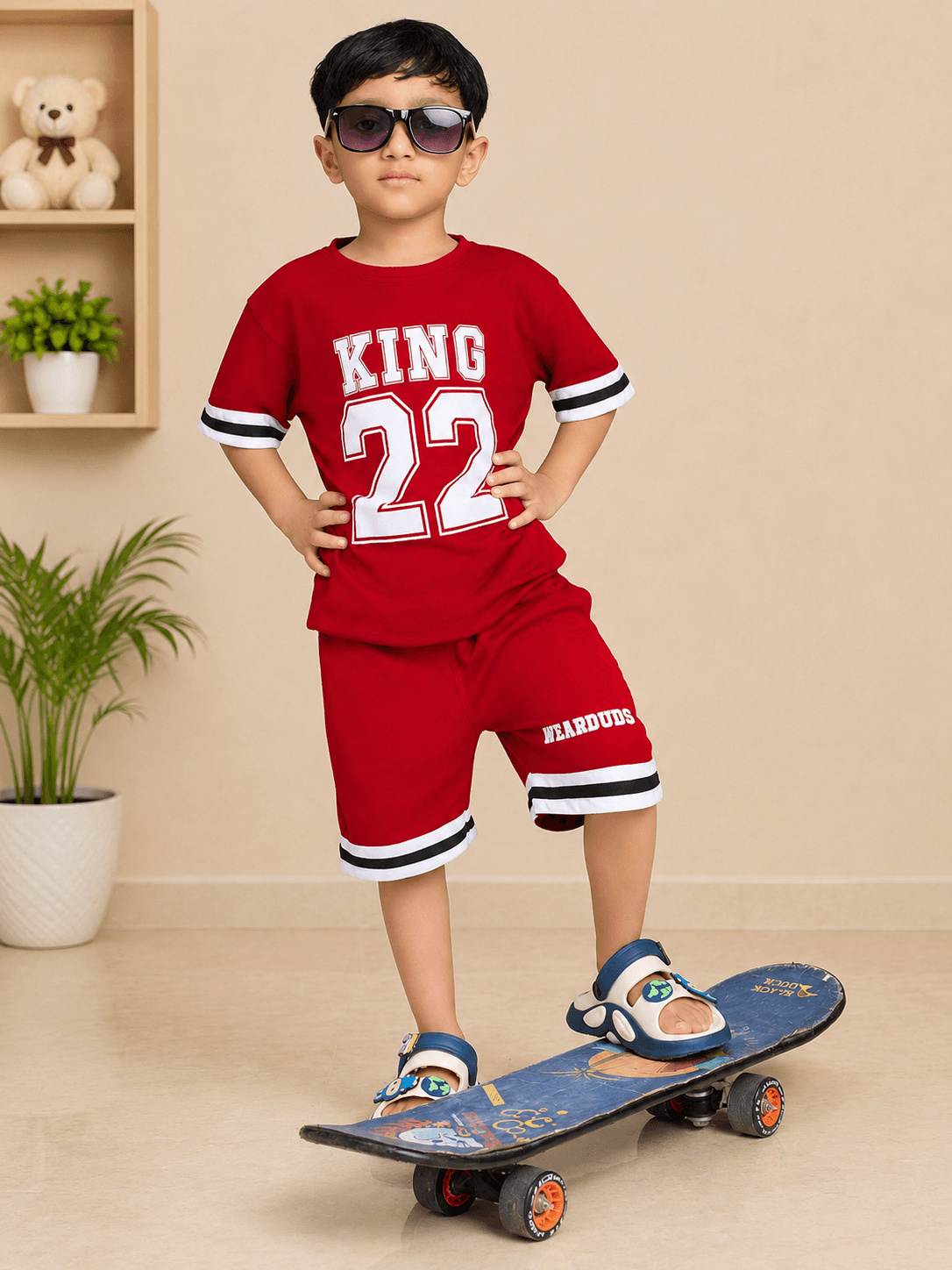 KING 22 VARSITY CO-ORD SET FOR BOYS GIRLS RED worn by a boy on a skateboard, showcasing sporty style.