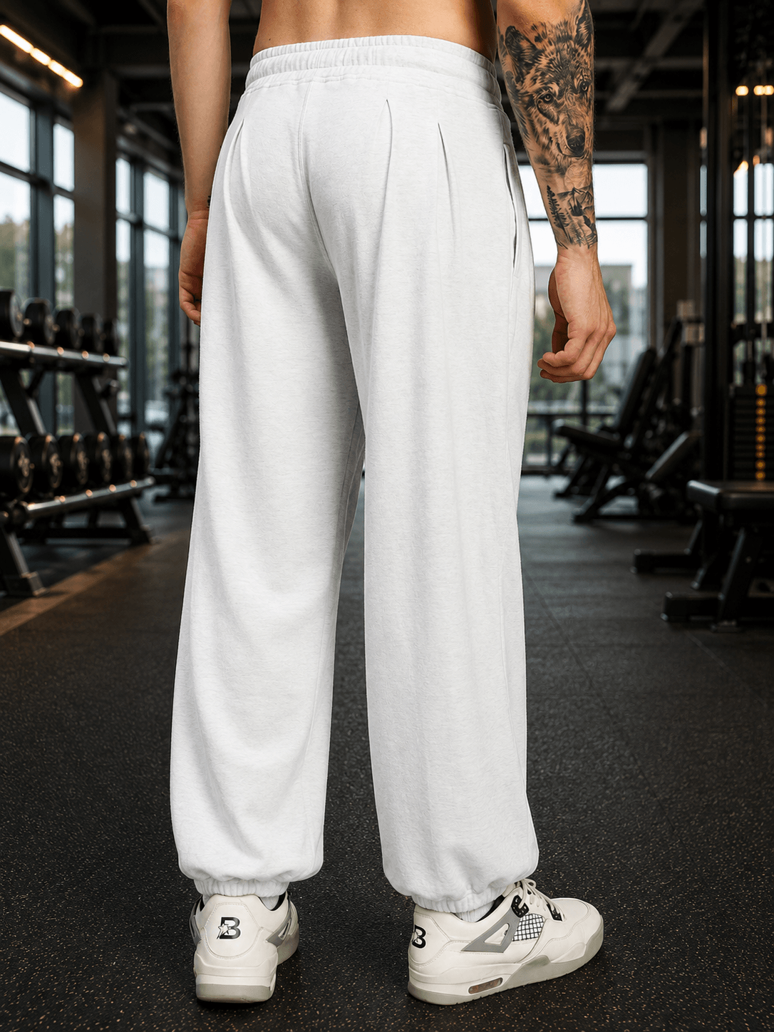 Back view of COOLFIT BAGGY LOOSE FIT JOGGER WHITE showing relaxed fit and comfortable design in a gym setting.