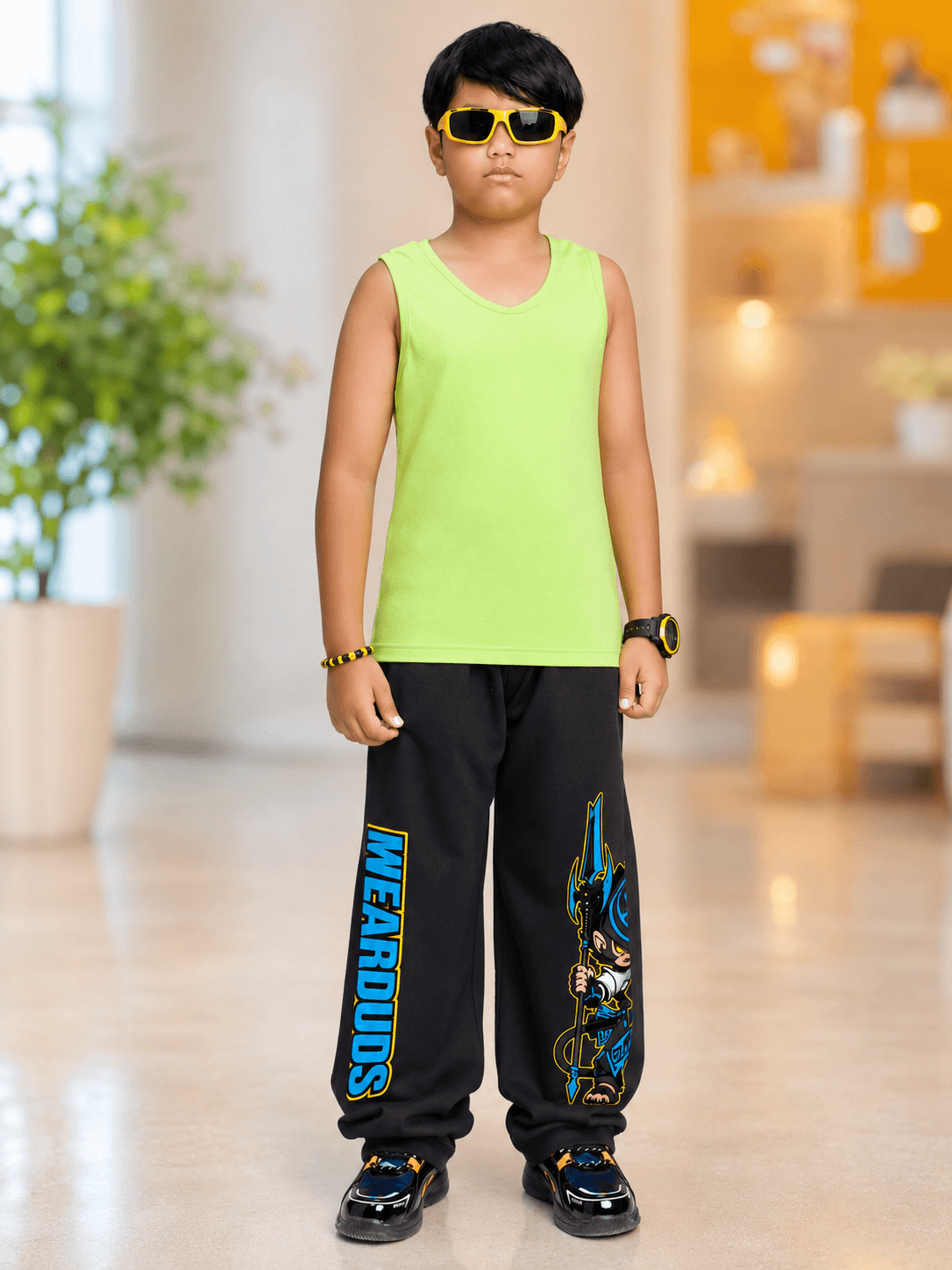 ELECTRIC WARRIOR JOGGER FOR BOYS GIRLS BLACK worn by a kid in a bright green tank top and stylish sunglasses.