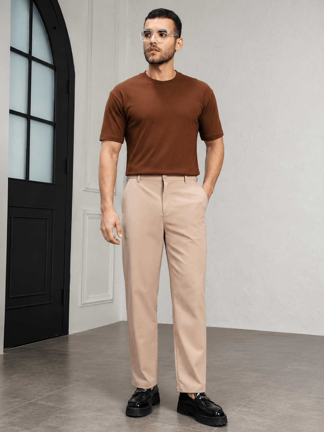 HIGH-FLEX TAILORED PANTS BEIGE styled with a brown shirt and black shoes in a modern interior.