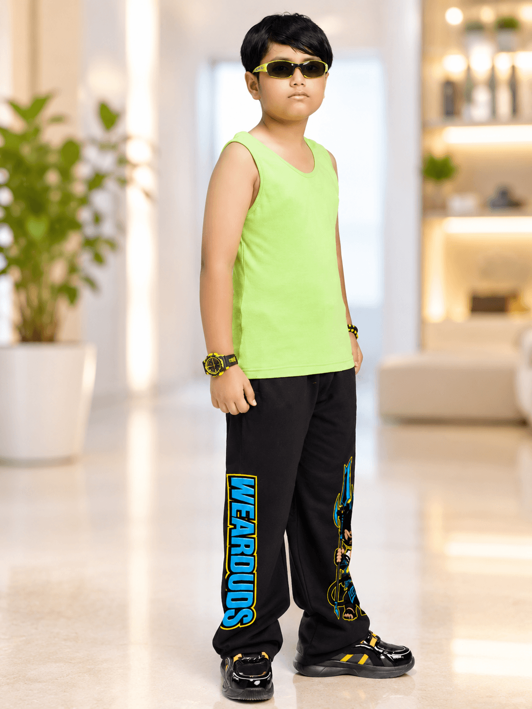 ELECTRIC WARRIOR CO-ORD FOR BOYS GIRLS NEON BLACK worn by a boy in a bright green tank and black sports pants.