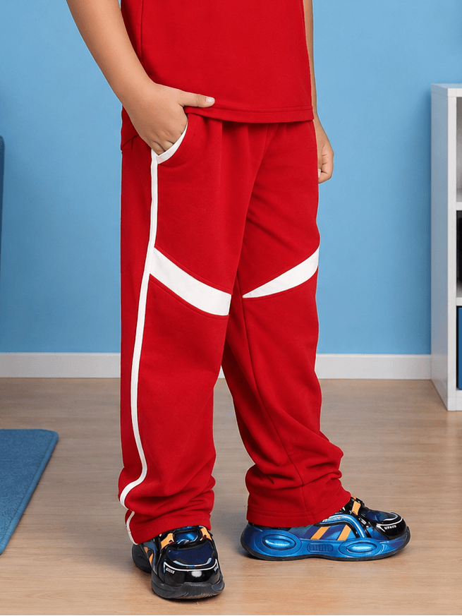KIDS ROSTER JOGGER FOR BOYS GIRLS RED WHITE displayed on a child in a playful setting with sporty shoes.