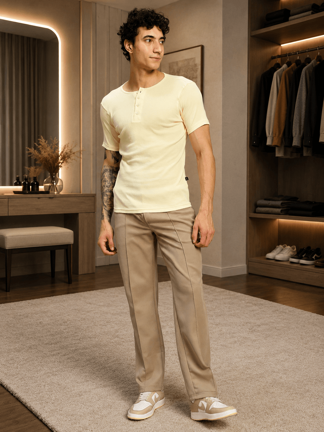 Man wearing ELITE TEXTURED FIT JOGGERS BEIGE and a yellow shirt in a contemporary indoor setting.