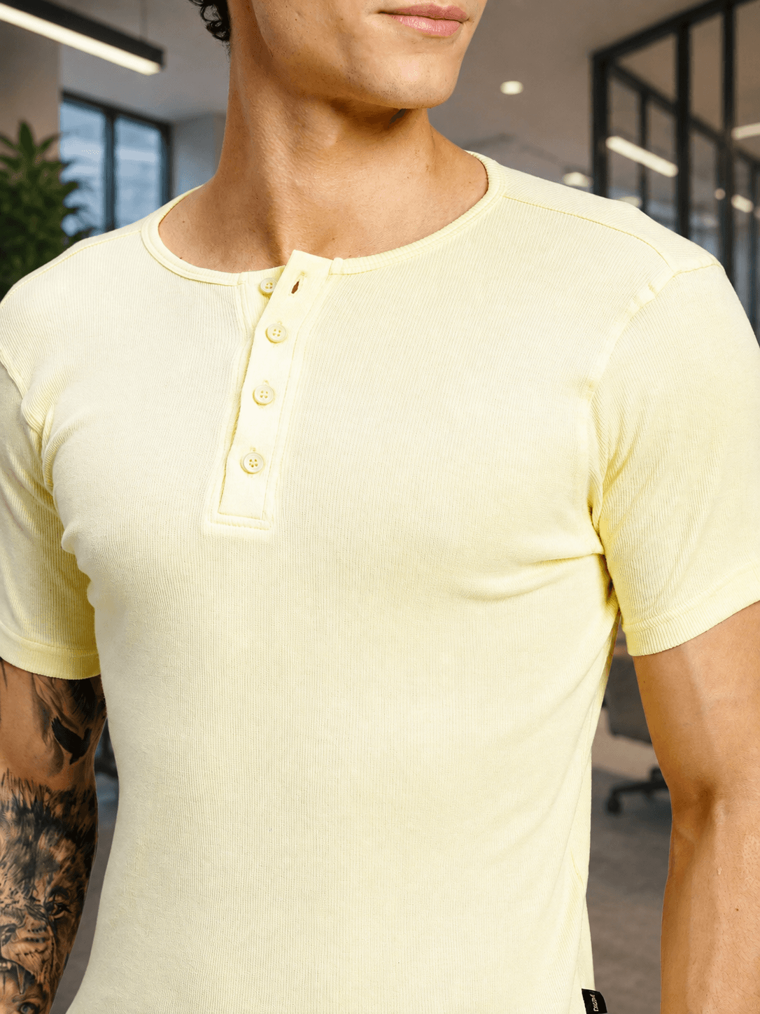 SPEARMINT VECTOR T-SHIRT CREAM YELLOW displayed on a model in a modern office setting, showcasing its stylish design.