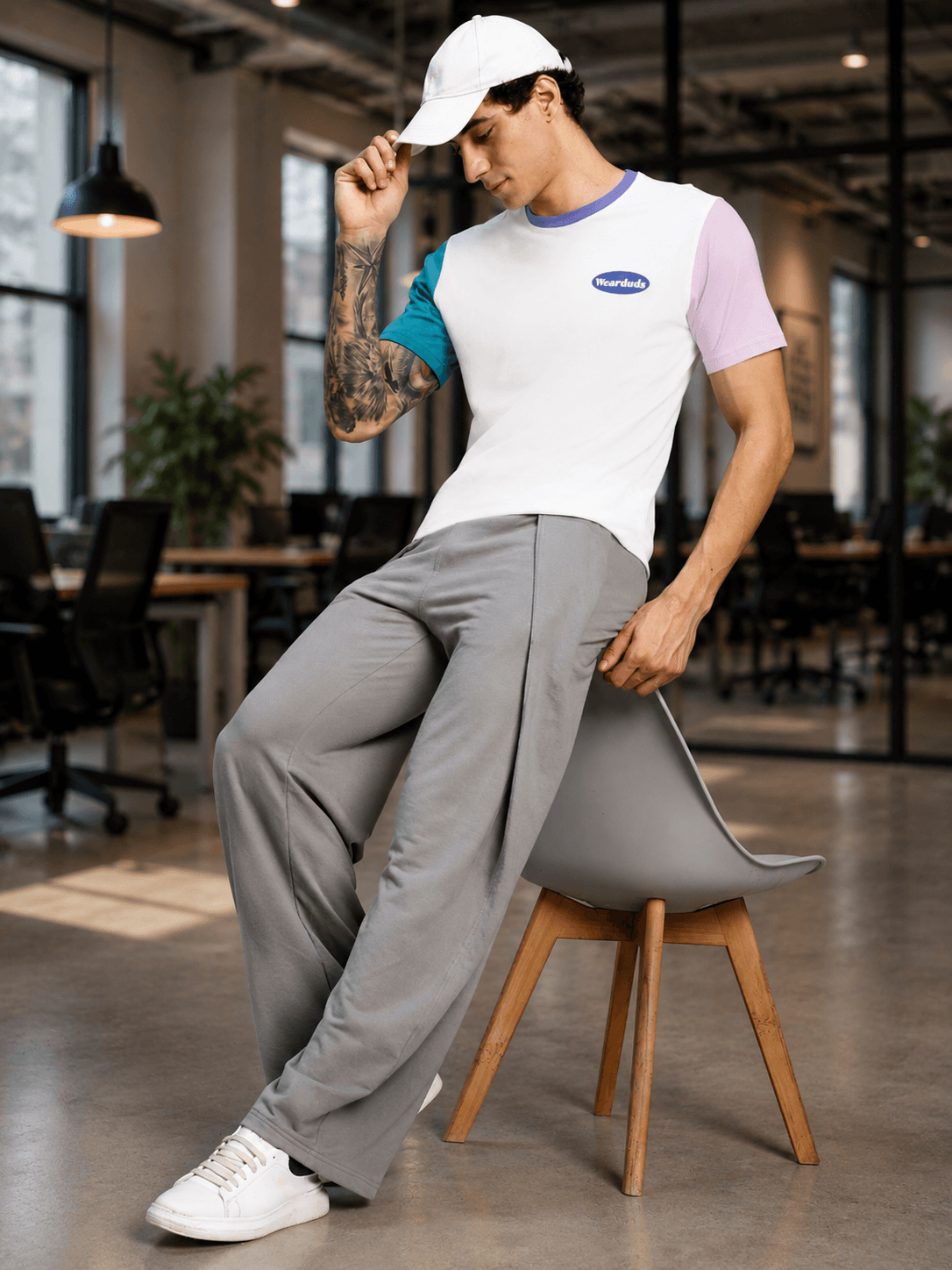 CHILL REGULAR FIT T-SHIRT WHITE MULTI worn by a model sitting on a chair in a modern office setting.