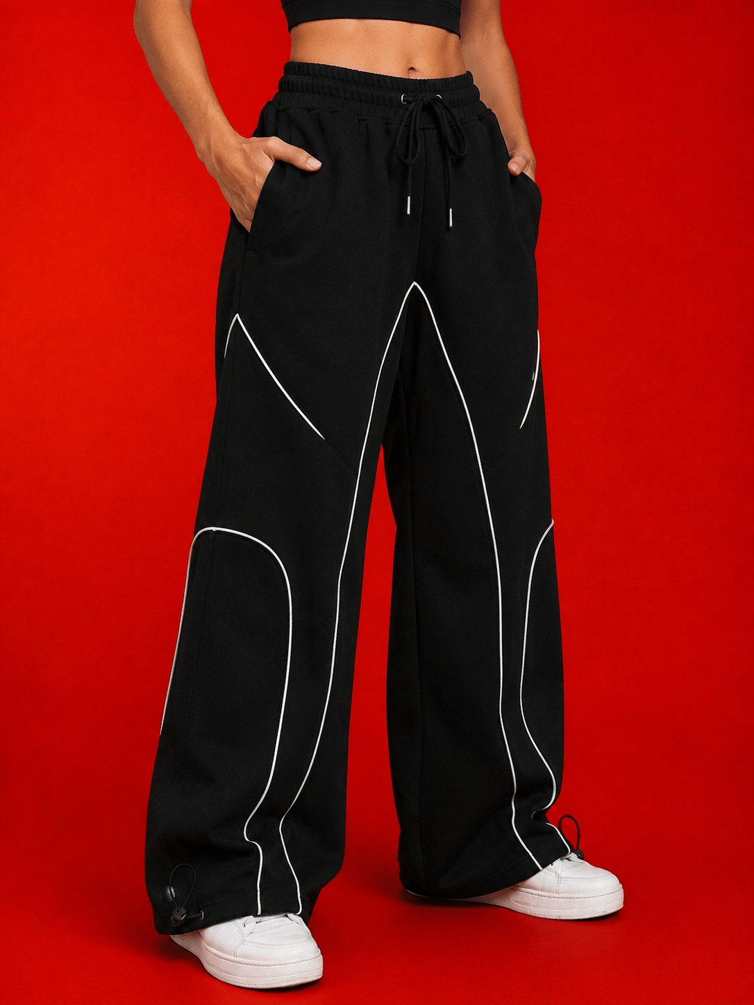 WOMEN SIGNATURE PIPING JOGGERS BLACK with contrast piping detail, relaxed fit joggers on red background.