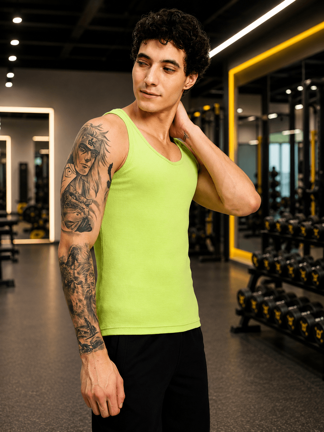 EASY WEAR VEST GYM T-SHIRT NEON GREEN showcased by a man in a gym setting, highlighting its vibrant colors.