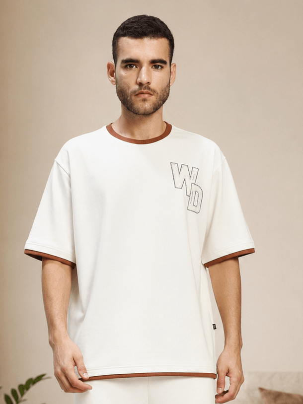 DOWNTOWN RELAXED FIT T-SHIRT WHITE model wearing a contemporary white tee with relaxed fit and brown accents.