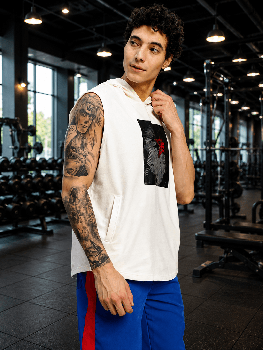 SHADOW FACE SLEEVELESS T-SHIRT WHITE worn by a tattooed man in a gym, showcasing bold street style and comfort.