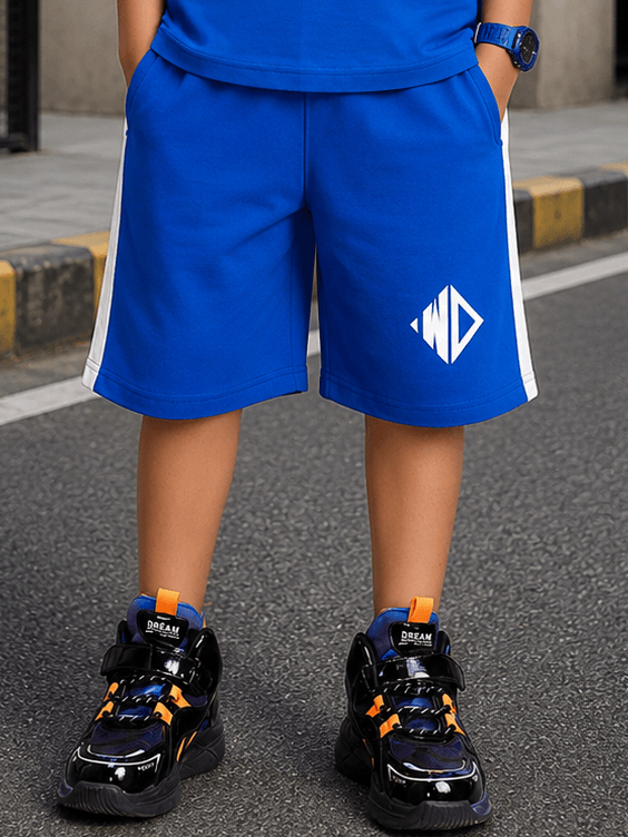 ELECTRIC FLEX SHORTS FOR BOYS GIRLS BLUE worn with stylish black sneakers on a city street.