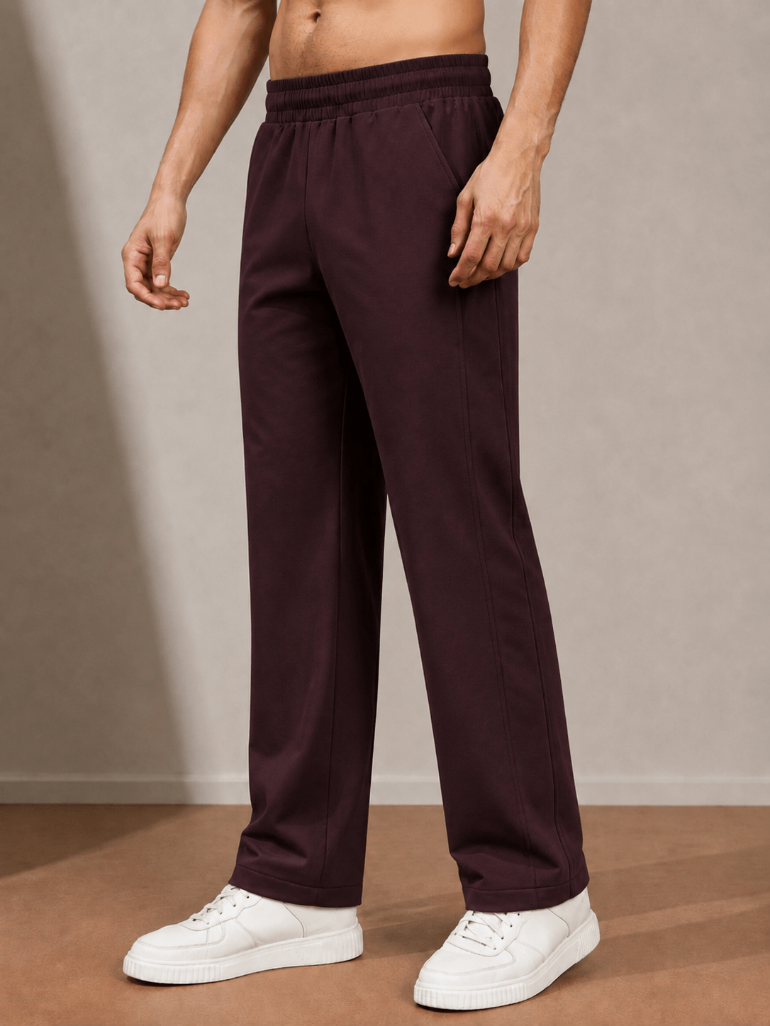 ATHLETIC DRESS TRACK TROUSERS MAROON worn by a model with white sneakers on a neutral background.