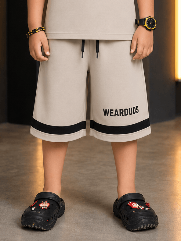 MONO EDGE SHORTS FOR BOYS GIRLS BEIGE worn by a child, featuring a trendy design and a comfortable fit.