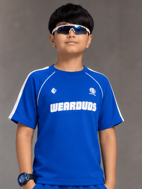 KIDS ROSTER T-SHIRT BOYS GIRLS BLUE worn by a boy posing confidently in stylish sunglasses and blue attire.