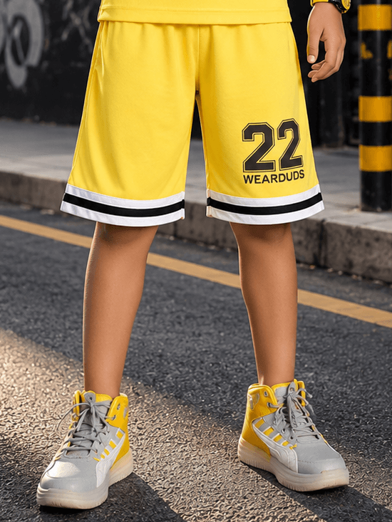 THE STREET SHORTS FOR BOYS GIRLS YELLOW worn by a child on the street, featuring the number 22 and stylish design.