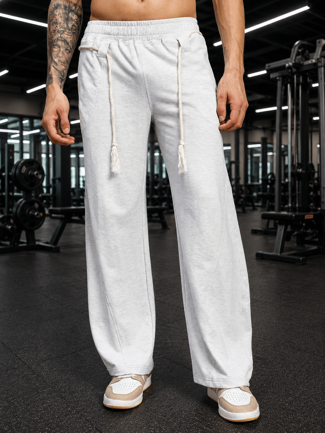 BAGGY DRIFT LIGHT JOGGER OFF-WHITE displayed on a model in a gym setting, showcasing its relaxed fit and stylish design.