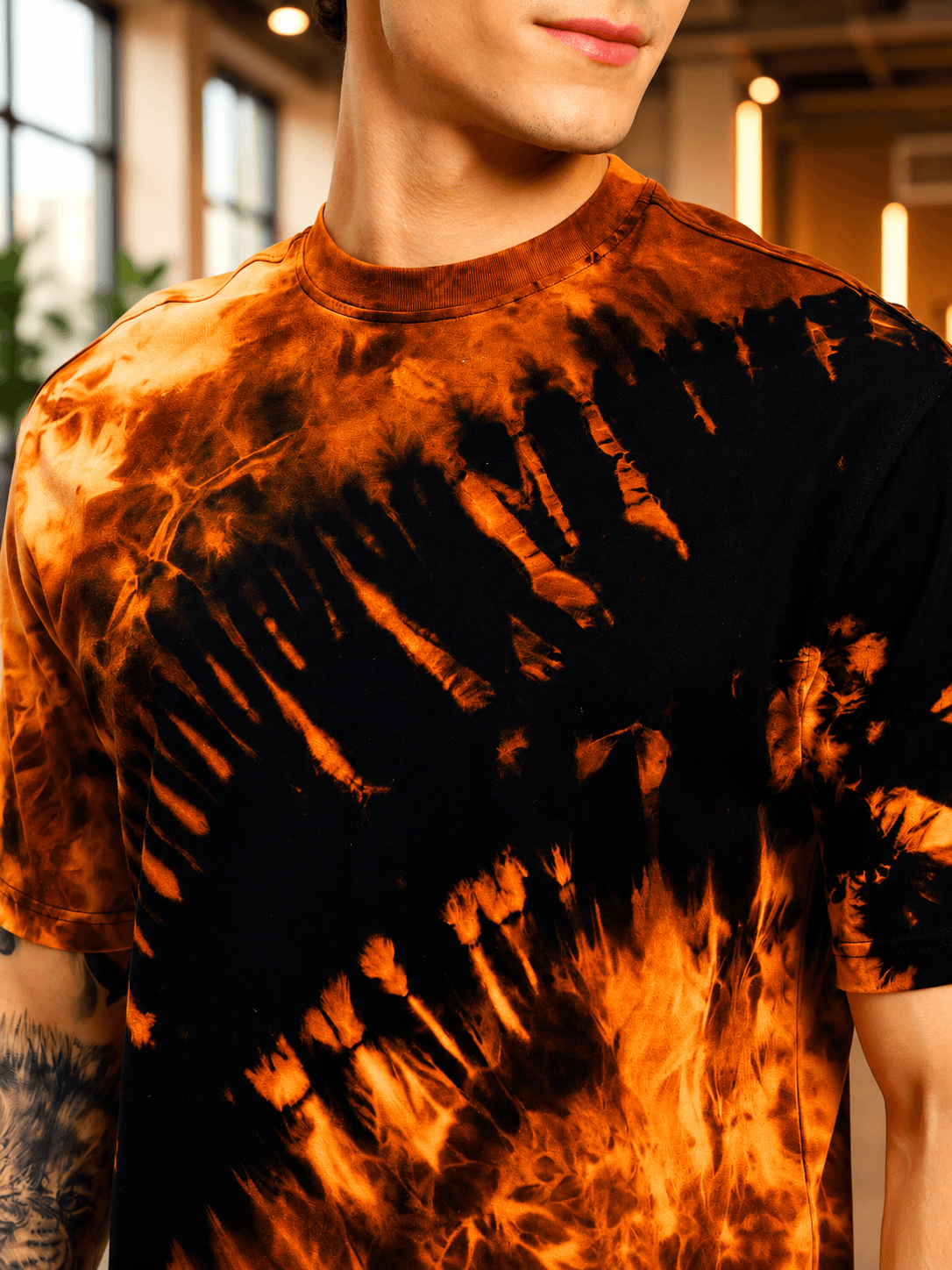 SOLAR TIE-DYE T-SHIRT BLACK FIRE ORANGE displayed on a model showcasing the vibrant tie-dye pattern.