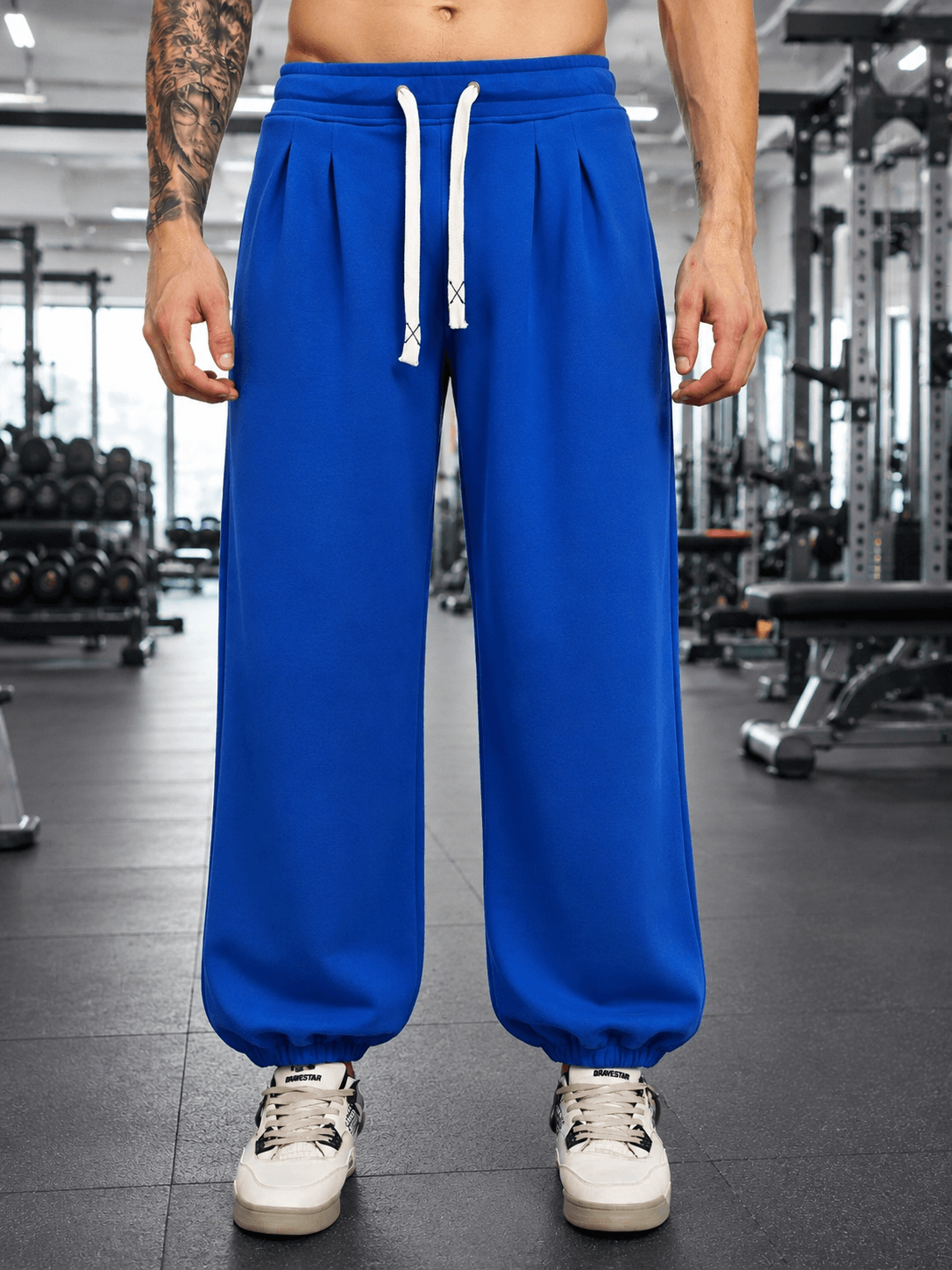 Model wearing COOLFIT BAGGY LOOSE FIT JOGGER BLUE in a gym setting, showcasing relaxed fit and vibrant color.