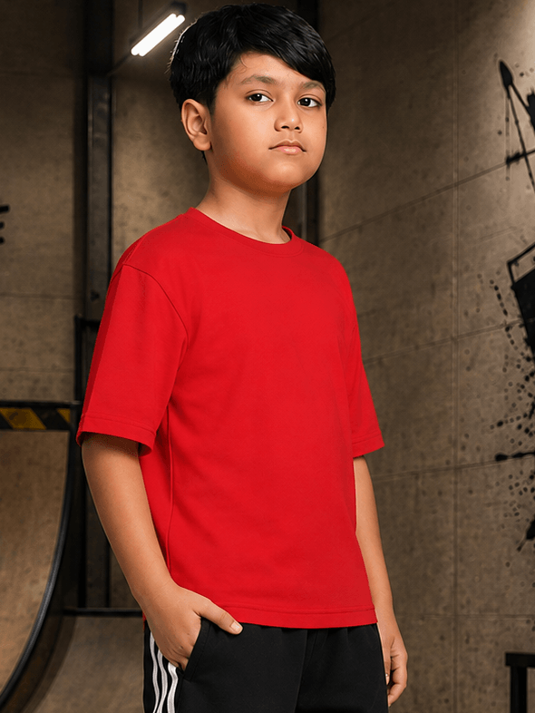 NEO STREET DROP T-SHIRT FOR BOYS GIRLS RED displayed by a young boy in a casual skate park setting.