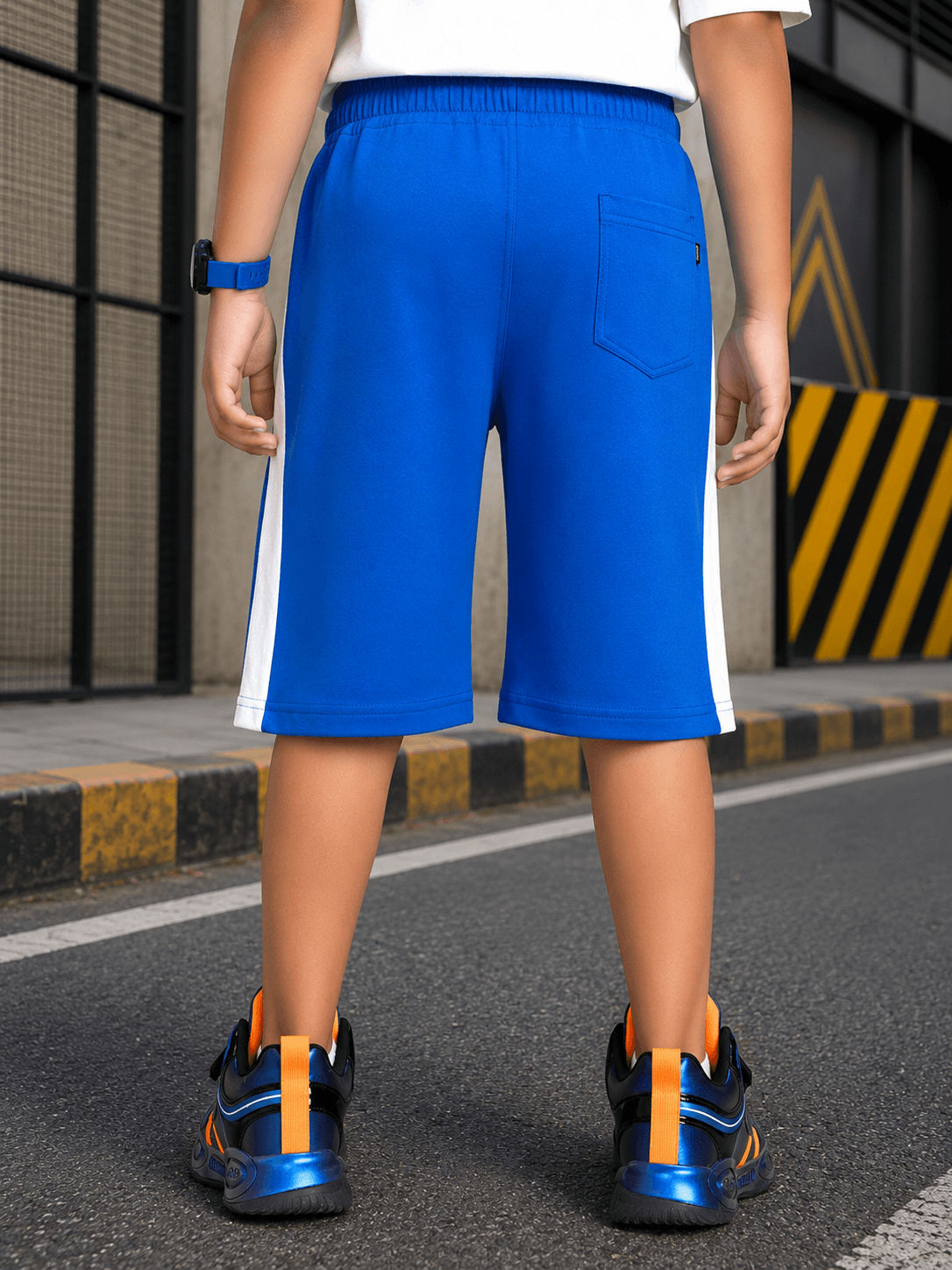 ELECTRIC FLEX SHORTS FOR BOYS GIRLS BLUE showcasing the back view on a child in a sporty setting.