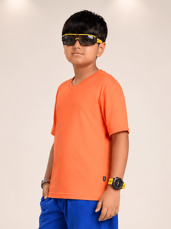 COOLFIT T-SHIRT FOR BOYS GIRLS ORANGE worn by a boy with sunglasses and stylish accessories.