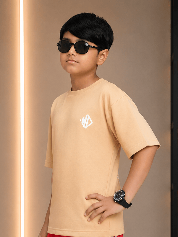 NEO-STREET DROP T-SHIRT FOR BOYS GIRLS OFF-BEIGE worn by a stylish boy with sunglasses in a trendy setting.