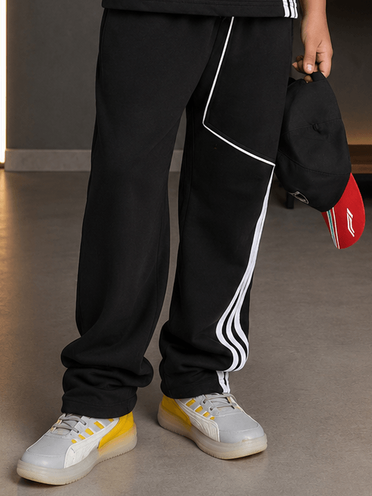 YOUTH CONTREST PIPING JOGGER FOR BOYS GIRLS OLIVE GREEN modeled with sporty shoes and a cap.