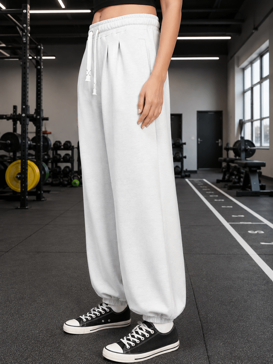 WOMEN COOLFIT BAGGY LOOSE FIT JOGGER WHITE displayed in a fitness studio, featuring a relaxed, stylish look.