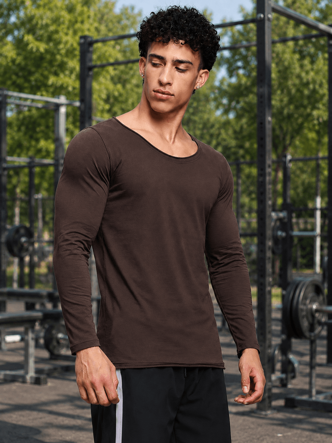 JOEL SLIM FIT COTTON SWEATSHIRT BROWN model wearing a brown long sleeve shirt in an outdoor gym setting.