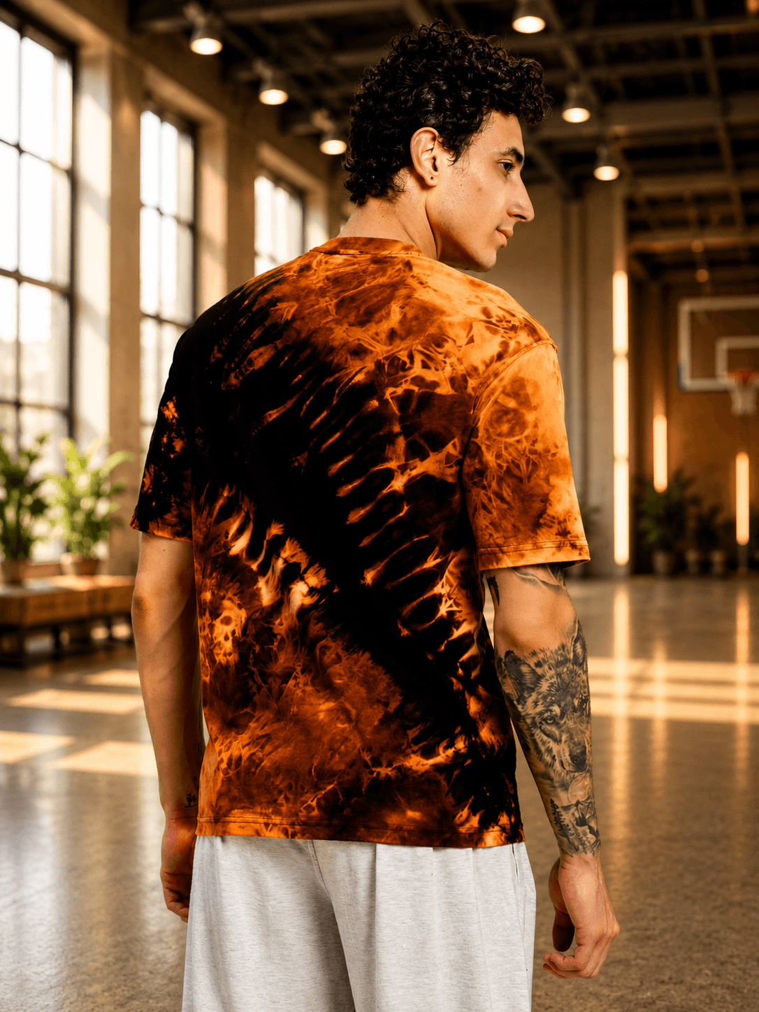 SOLAR TIE-DYE T-SHIRT BLACK FIRE ORANGE displayed on a model in a gym setting.
