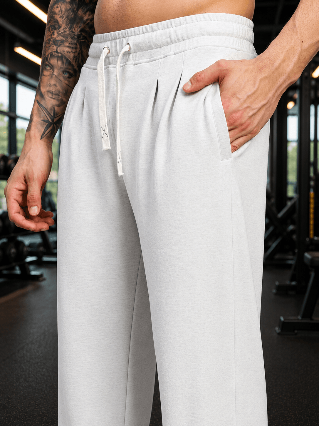 COOLFIT BAGGY LOOSE FIT JOGGER WHITE close-up of comfortable joggers with pockets in a gym setting.