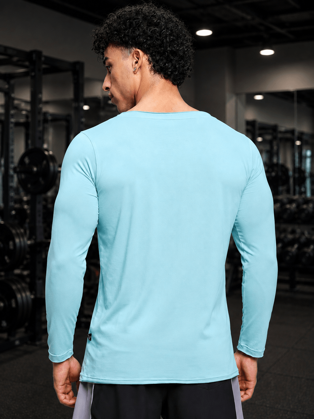 Back view of a man wearing a JOEL SLIM FIT COTTON SWEATSHIRT SKY BLUE in a gym setting.