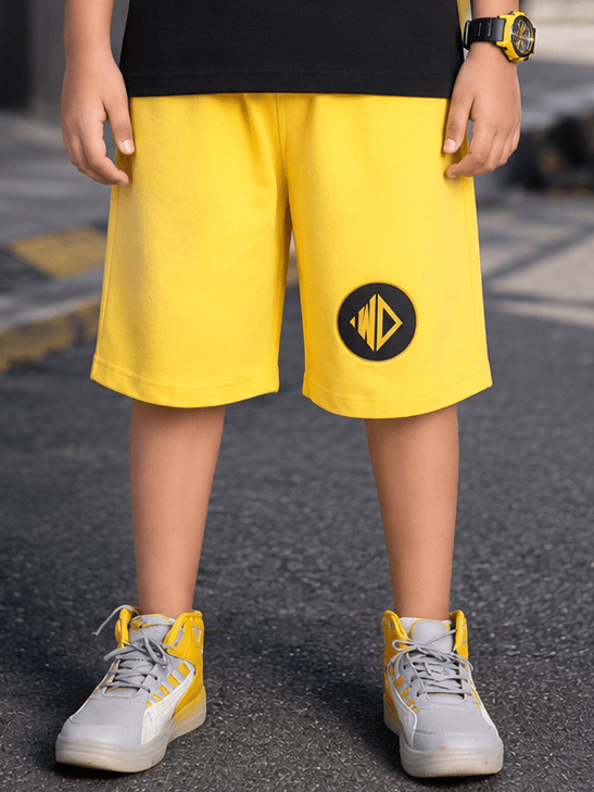 MIDNIGHT BAT SHORTS FOR BOYS GIRLS YELLOW worn by a child, showcasing vibrant yellow color and sporty design.