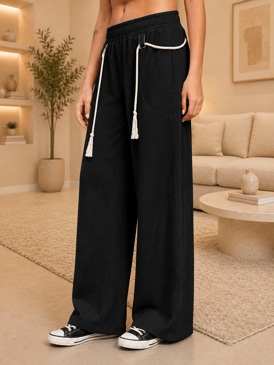 WOMEN COOLFIT BAGGY LOOSE FIT JOGGER BLACK modeled in a casual living room setting, showcasing a relaxed silhouette.