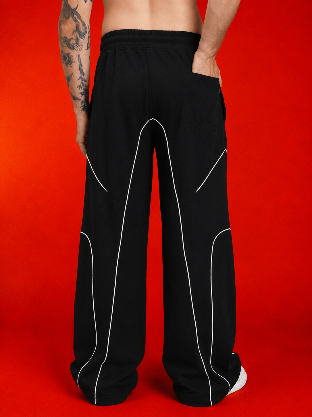 SIGNATURE PIPING JOGGERS BLACK showcased from the back, featuring contrast piping on a black fabric design.