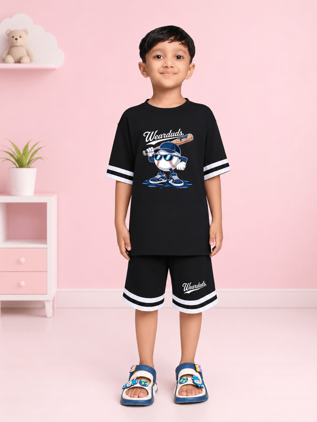 MASCOT GRAPHIC SHORTS FOR BOYS GIRLS BLACK WHITE worn by a boy in a stylish black outfit with a playful graphic.