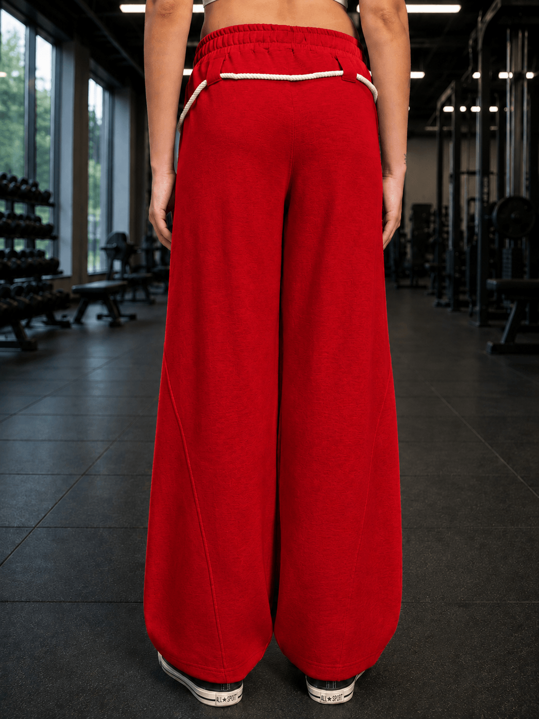 Back view of WOMEN BAGGY DRIFT LIGHT JOGGER RED showcasing relaxed fit and stylish design in a gym setting.