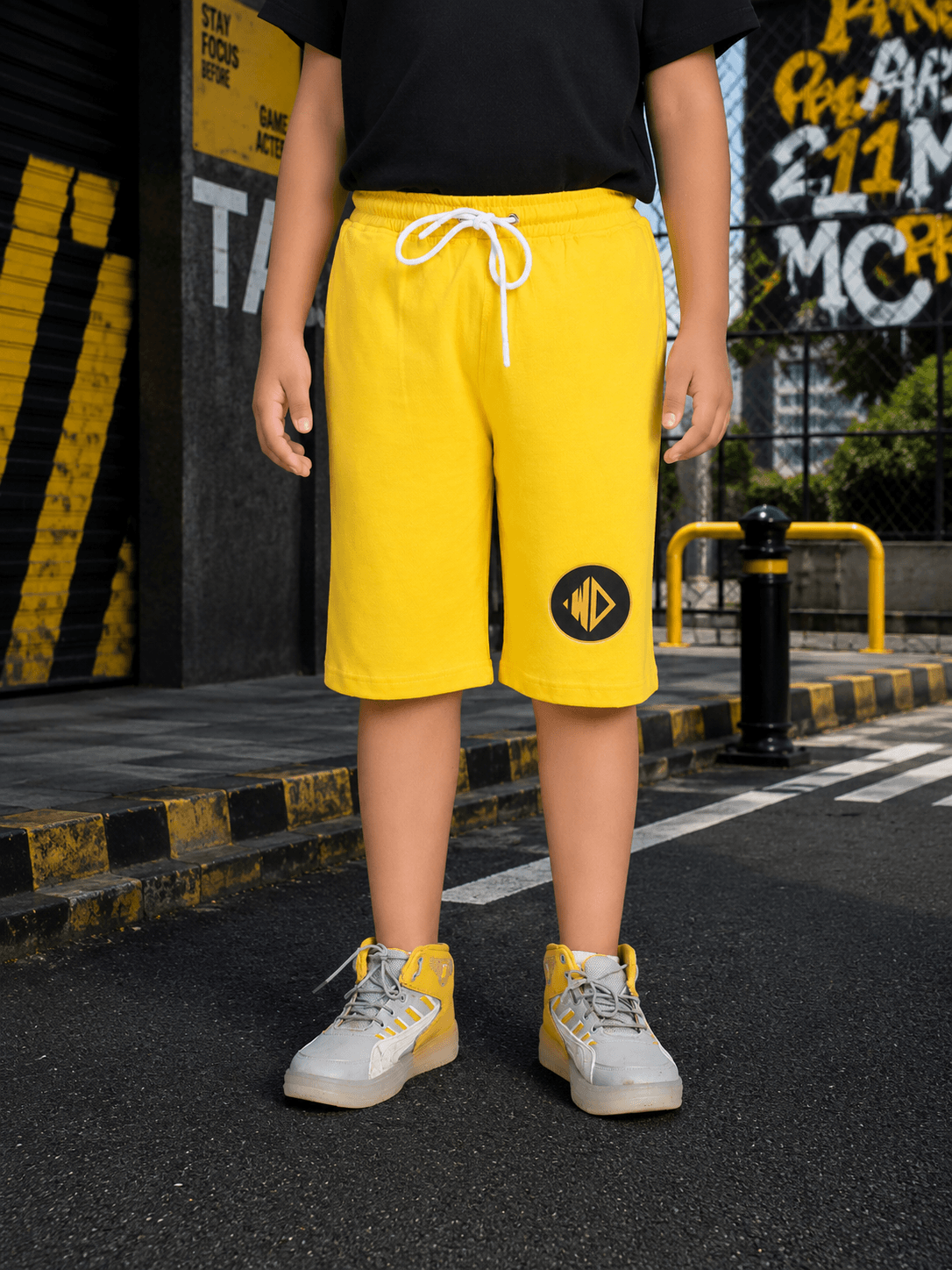 MIDNIGHT BAT SHORTS FOR BOYS GIRLS YELLOW worn by a child, showcasing stylish design and vibrant color.