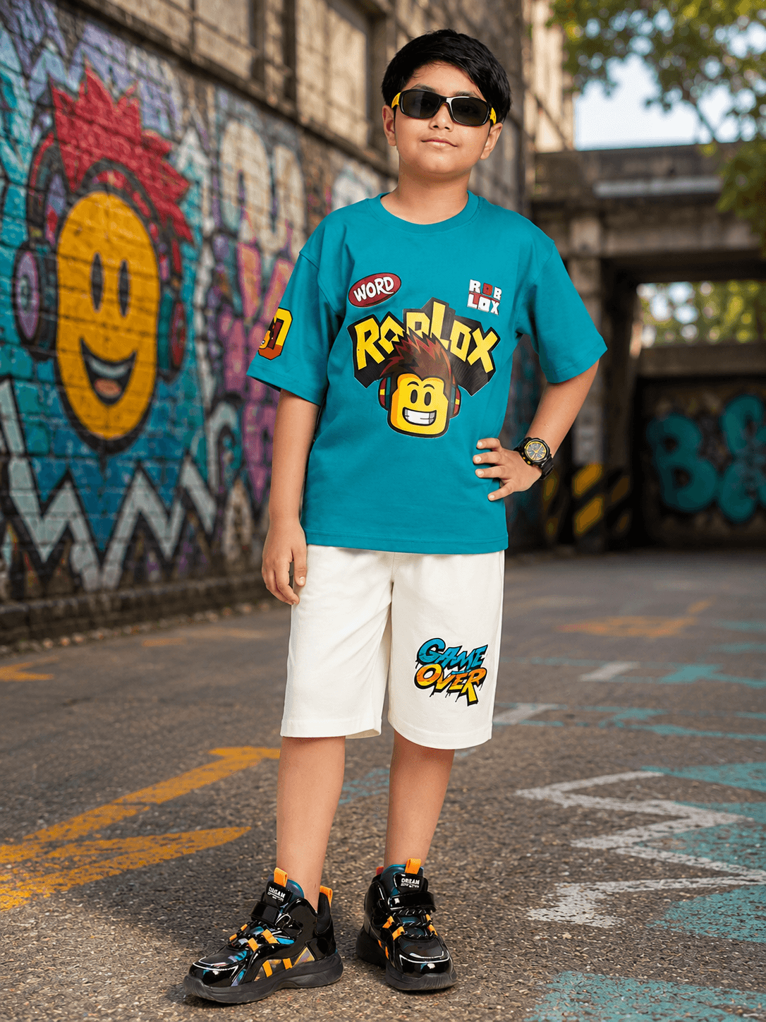 JUNIOR CO-ORD FOR BOYS GIRLS BLUE WHITE stylish kids' outfit in blue and white with graffiti background, perfect for casual outings.