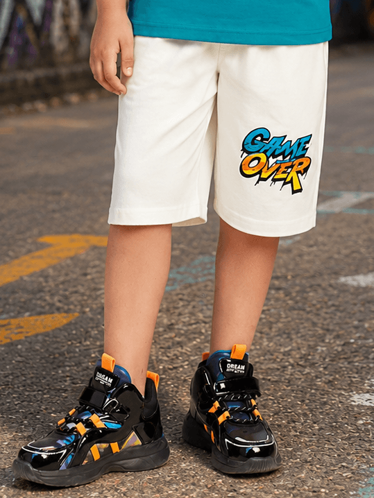 JUNIOR SHORTS FOR BOYS GIRLS WHITE worn by a kid, featuring a 'GAME OVER' graphic.