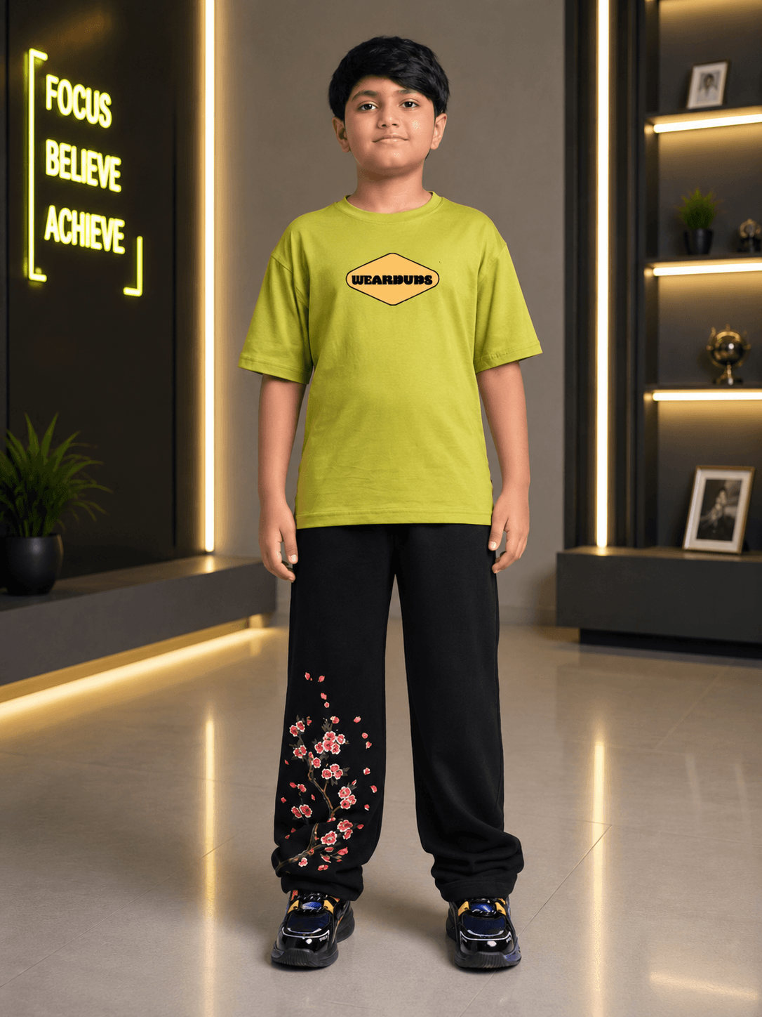 BEAR ON BOARD JOGGER FOR BOYS GIRLS BLACK worn by a boy in a stylish setting