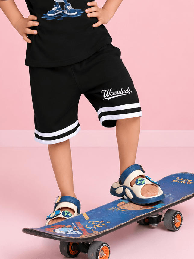 MASCOT GRAPHIC SHORTS FOR BOYS GIRLS BLACK WHITE on a child standing on a skateboard, showcasing playful streetwear style.