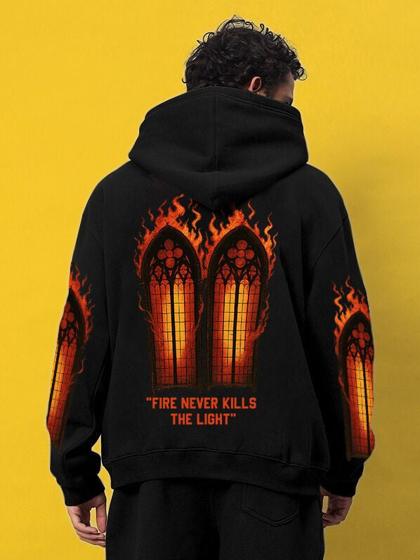 Man wearing FIRE NEVER KILLS THE LIGHT PRINTED FLEECE HOODIE BLACK with fiery gothic window design, showcasing urban style.