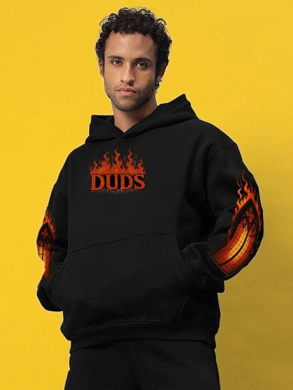 Model wearing FIRE NEVER KILLS THE LIGHT PRINTED FLEECE HOODIE BLACK with bold graphic and flame details, street-style fashion.