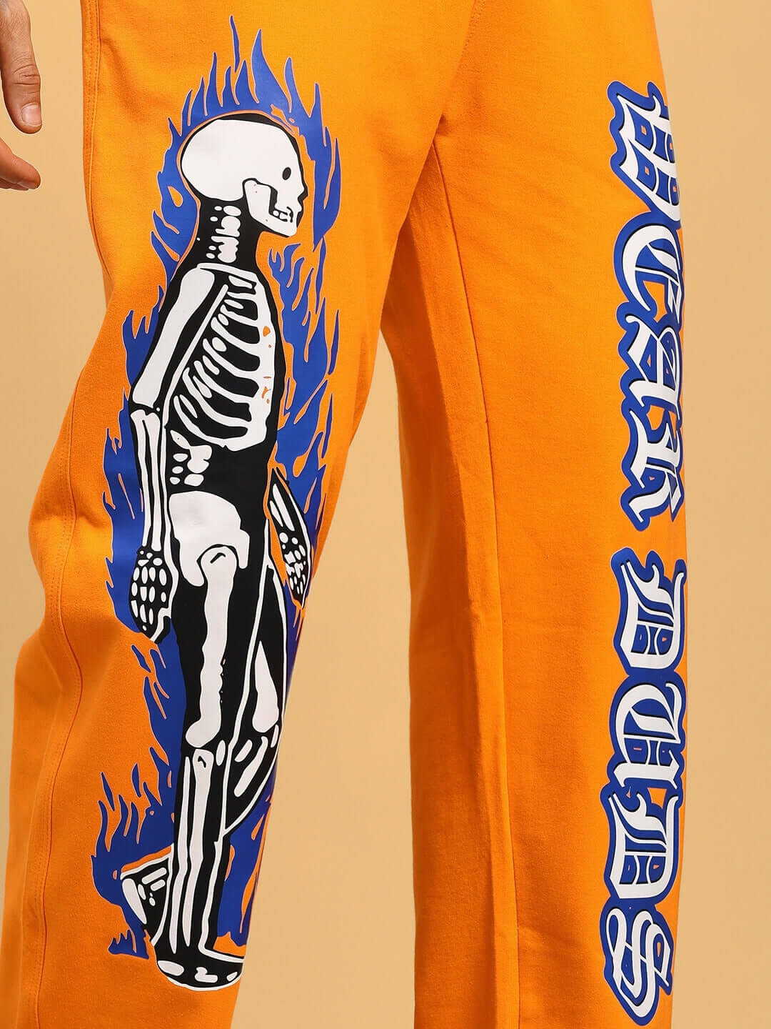 FLAMING SKELETON PRINTED RELAXED FIT JOGGER ORANGE with graphic design on orange fabric