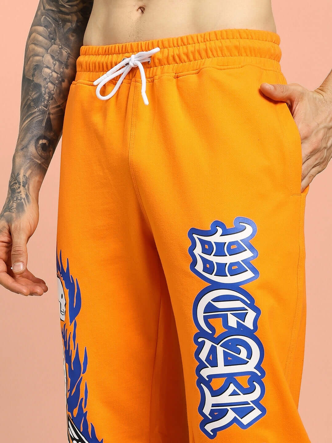 FLAMING SKELETON PRINTED RELAXED FIT JOGGER ORANGE with bold graffiti design on orange fabric, custom fit options available.
