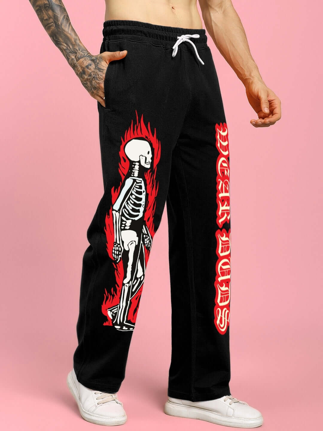 FLAMING SKELETON PRINTED RELAXED FIT JOGGER BLACK with edgy design and elastic waistband displayed on male model.